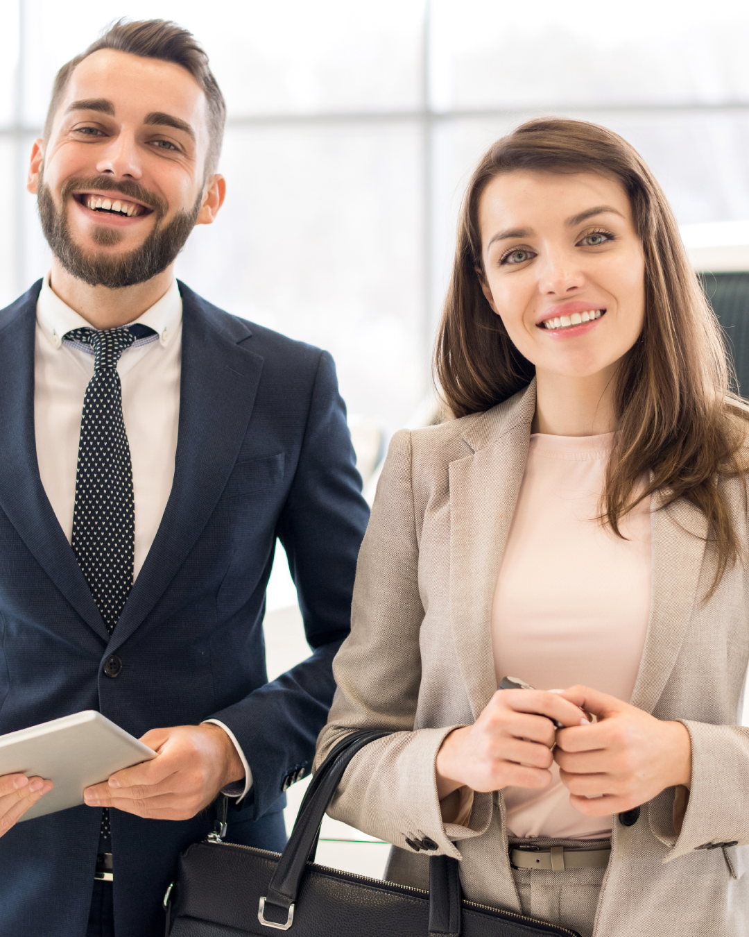 Hombe y mujer en una oficina sonriendo.